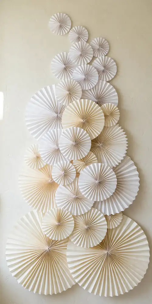 Wall of large white and cream paper fans in graduating sizes
