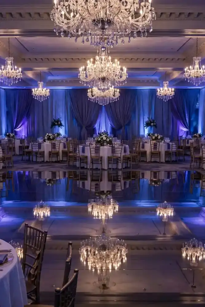 Mirrored dance floor reflecting chandeliers at reception