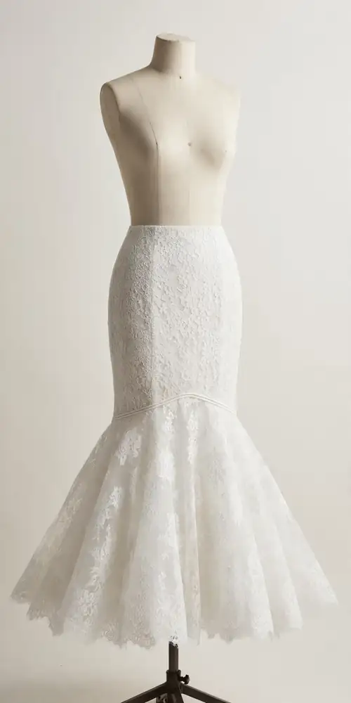 White lace mermaid wedding dress with drop waist on a dress form