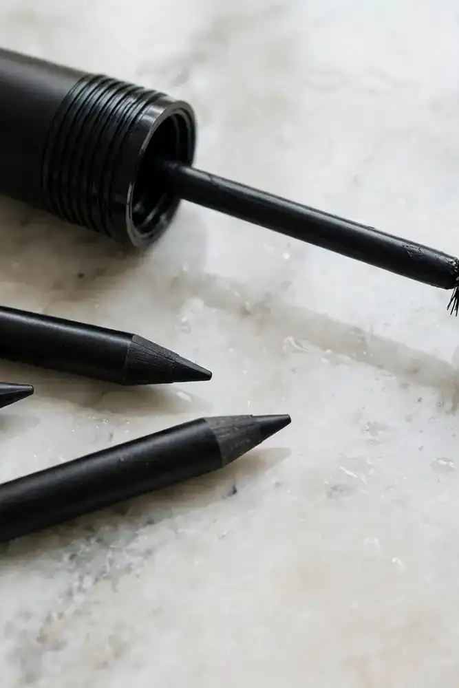 Waterproof mascara wand and eyeliner pencils on a vanity