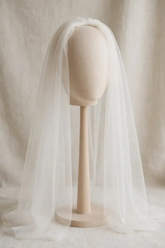 Drop bridal veil of smooth sheer tulle draped over a head stand